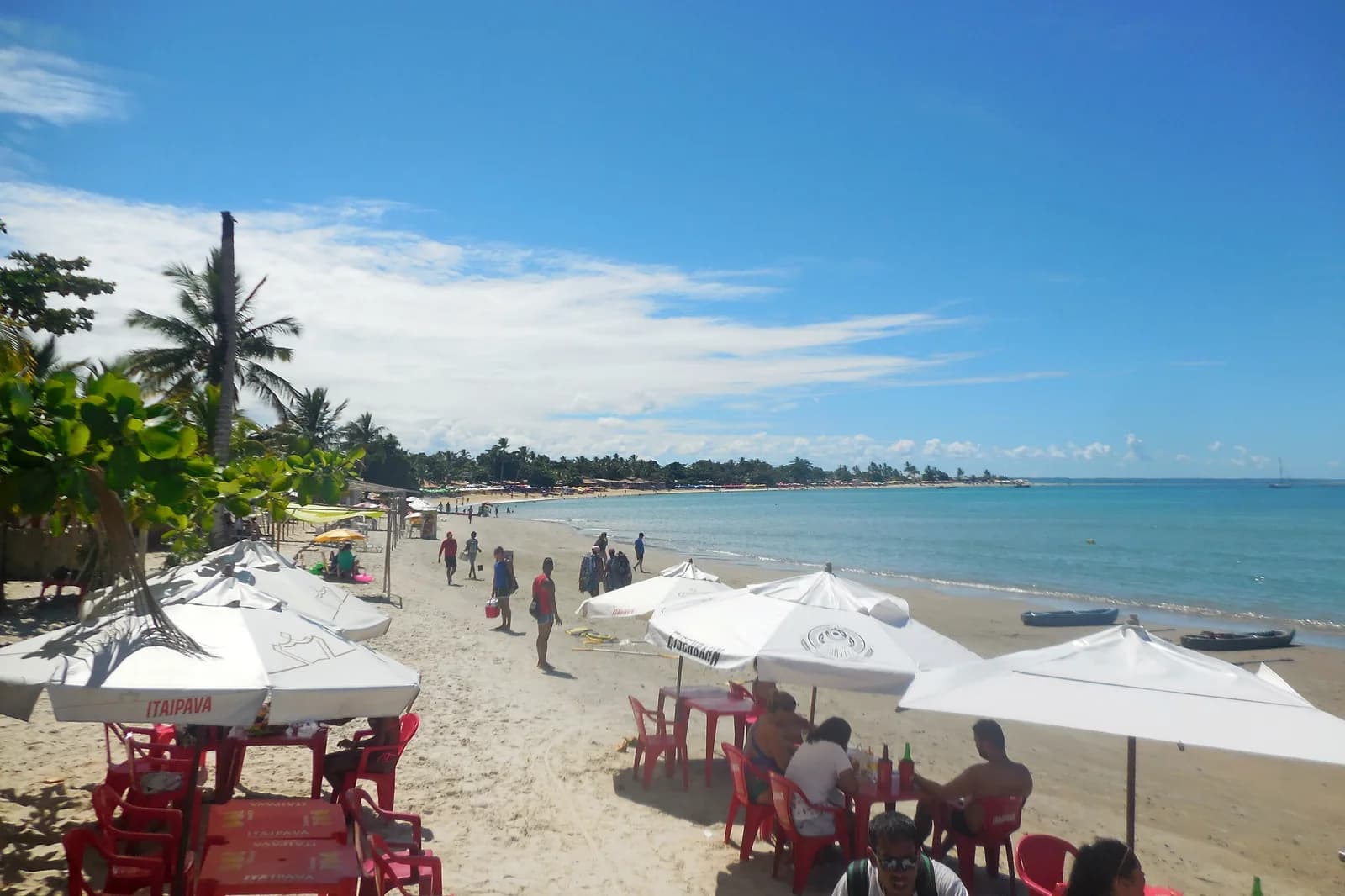 Barracas, coqueiros e mar na praia de Coroa Vermelha
